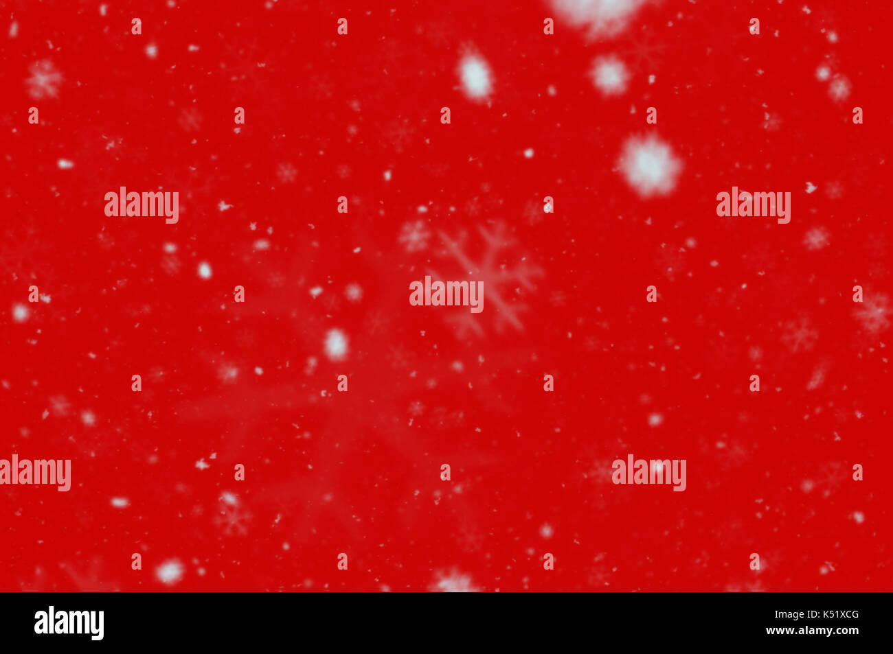 Fiocchi di neve bianca blur su sfondo rosso. neve effetto bokeh abstract Natale e Anno Nuovo elemento di design. Foto Stock