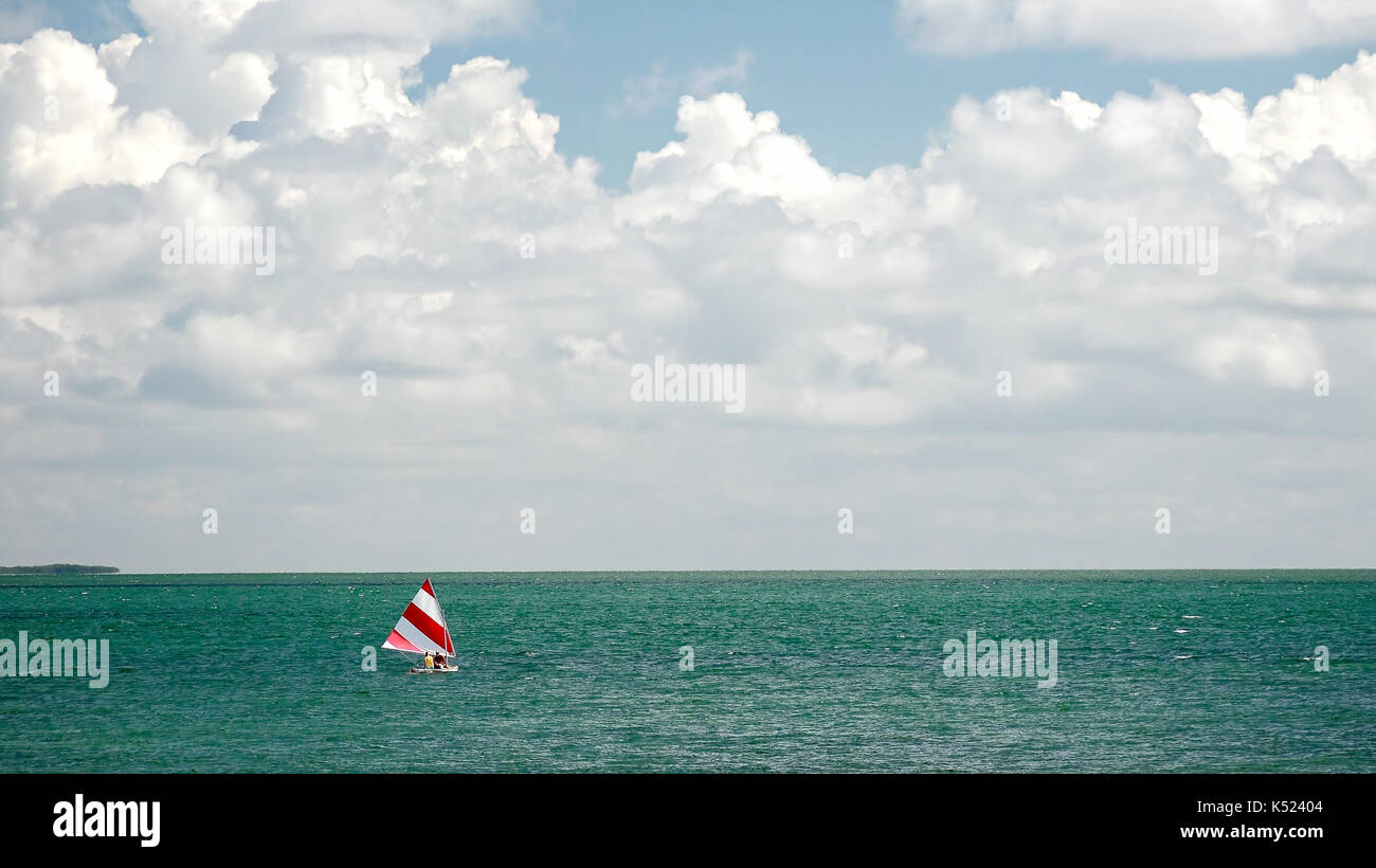 Barca a vela da sogno con la rossa e bianca a strisce vela nell'oceano tropicale della Florida keys Foto Stock