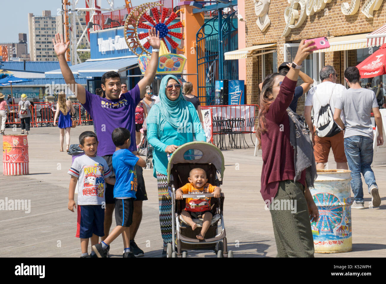 Una famiglia musulmana prendendo un selfie sul Boardwalk in Consy Isola, Brooklyn, New York City. Foto Stock