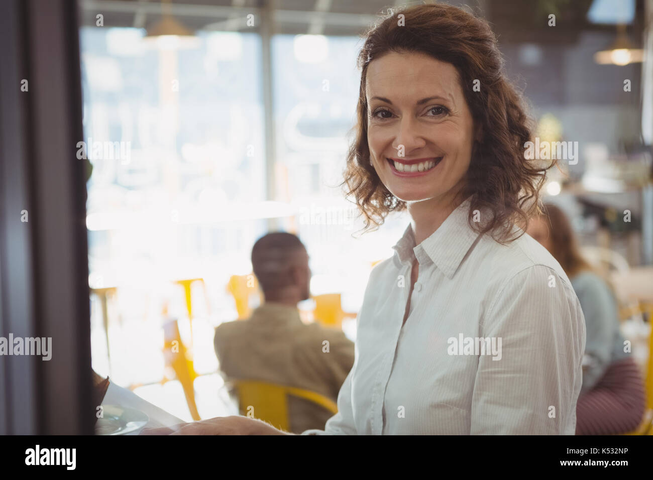 Ritratto di felice imprenditrice seduta in cafe Foto Stock