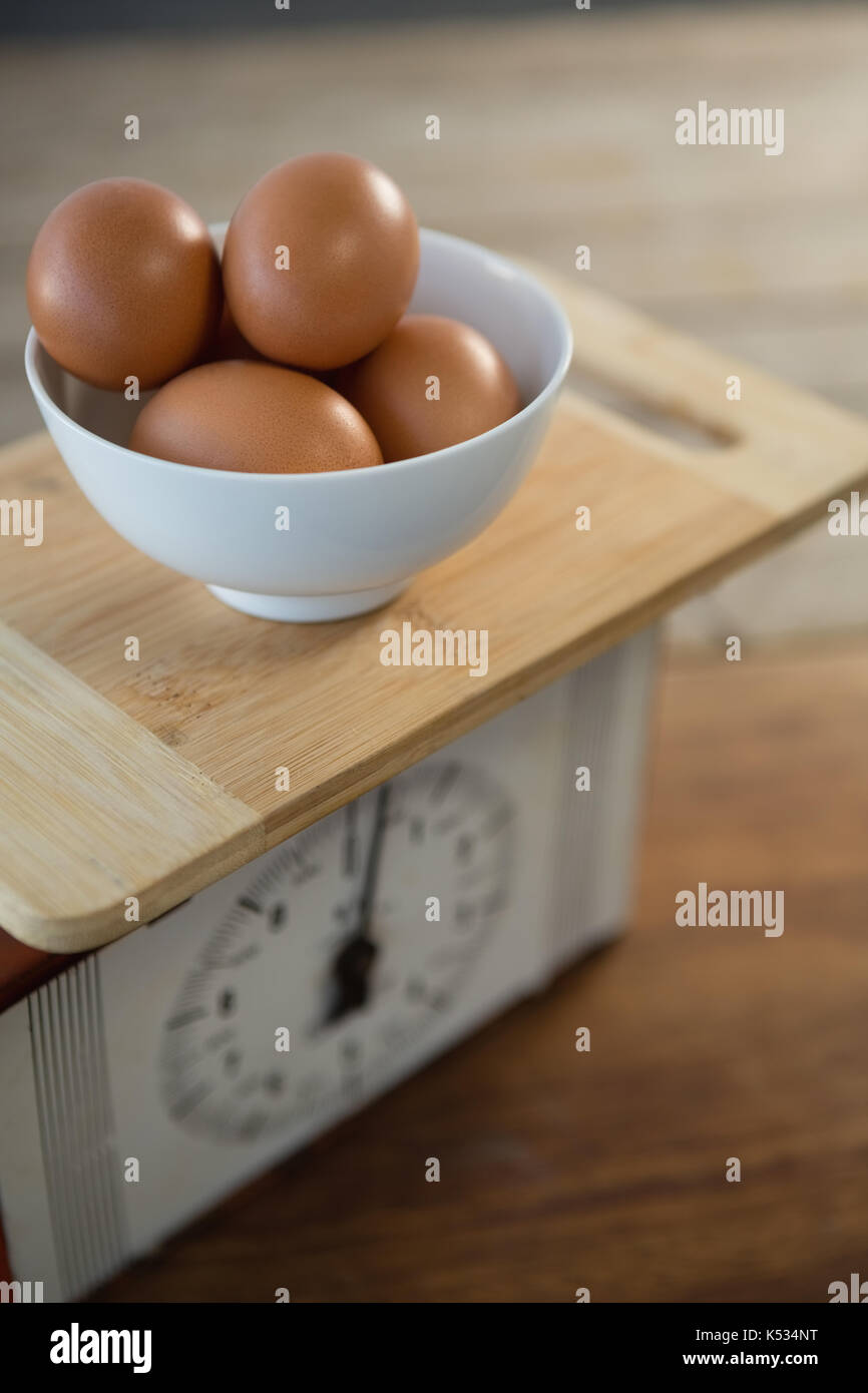 Rosolare le uova in una terrina sulla bilancia a tavola Foto Stock
