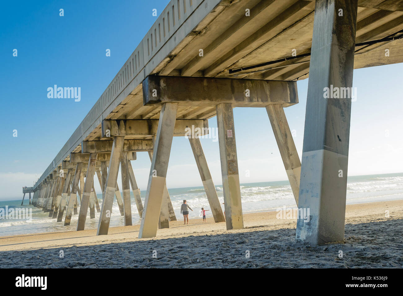 Donna e bambino che gioca sotto Wrightsville Pier, Wilmington, NC Foto Stock