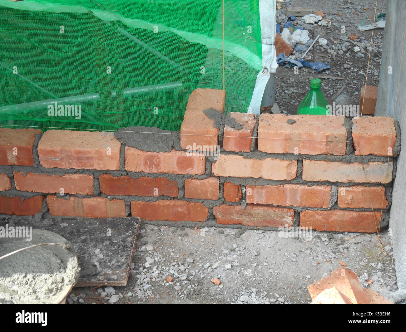 Selangor, Malaysia - gennaio 15, 2017: muratore laici mattoni di argilla blocco e impilata insieme con malta di cemento per formare pareti in corrispondenza della costruzione Foto Stock