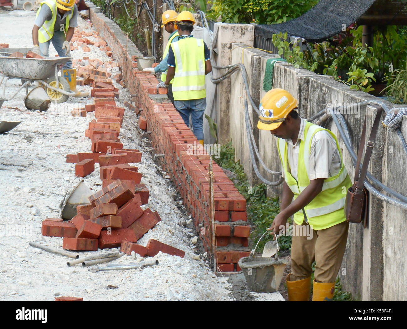 Selangor, Malaysia - gennaio 15, 2017: muratore laici mattoni di argilla blocco e impilata insieme con malta di cemento per formare pareti in corrispondenza della costruzione Foto Stock
