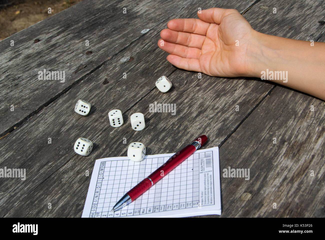 Una donna di mano lancia i dadi e gioca un yahtzee, gioco di dadi Foto Stock