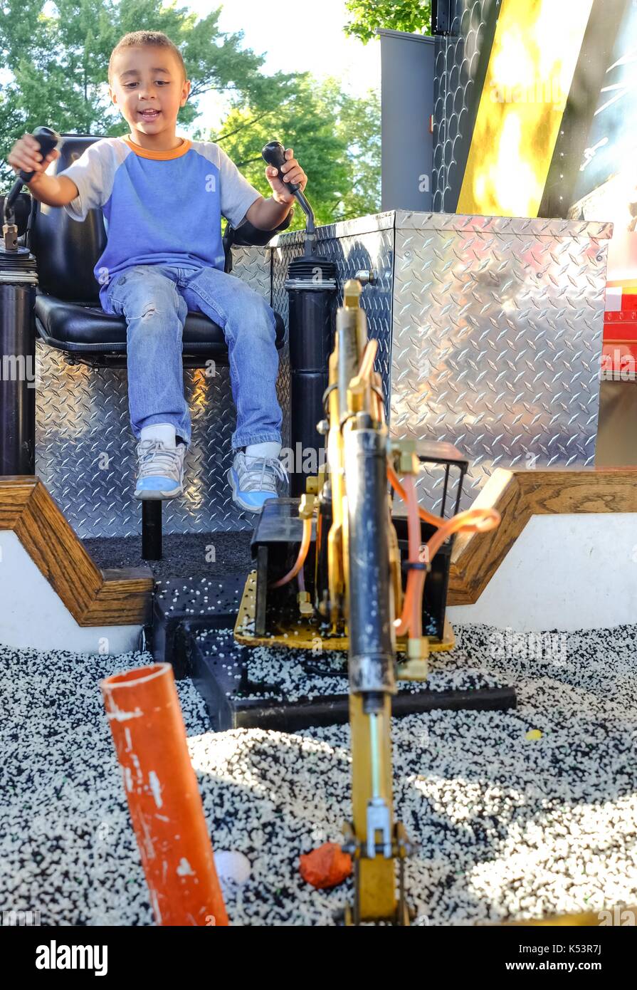 ST.PAUL, Minnesota, USA - AGOSTO 2017: Padiglione del lavoro con un escavatore modello in funzione da un bambino di 5 anni alla Minnesota State Fair. Foto Stock