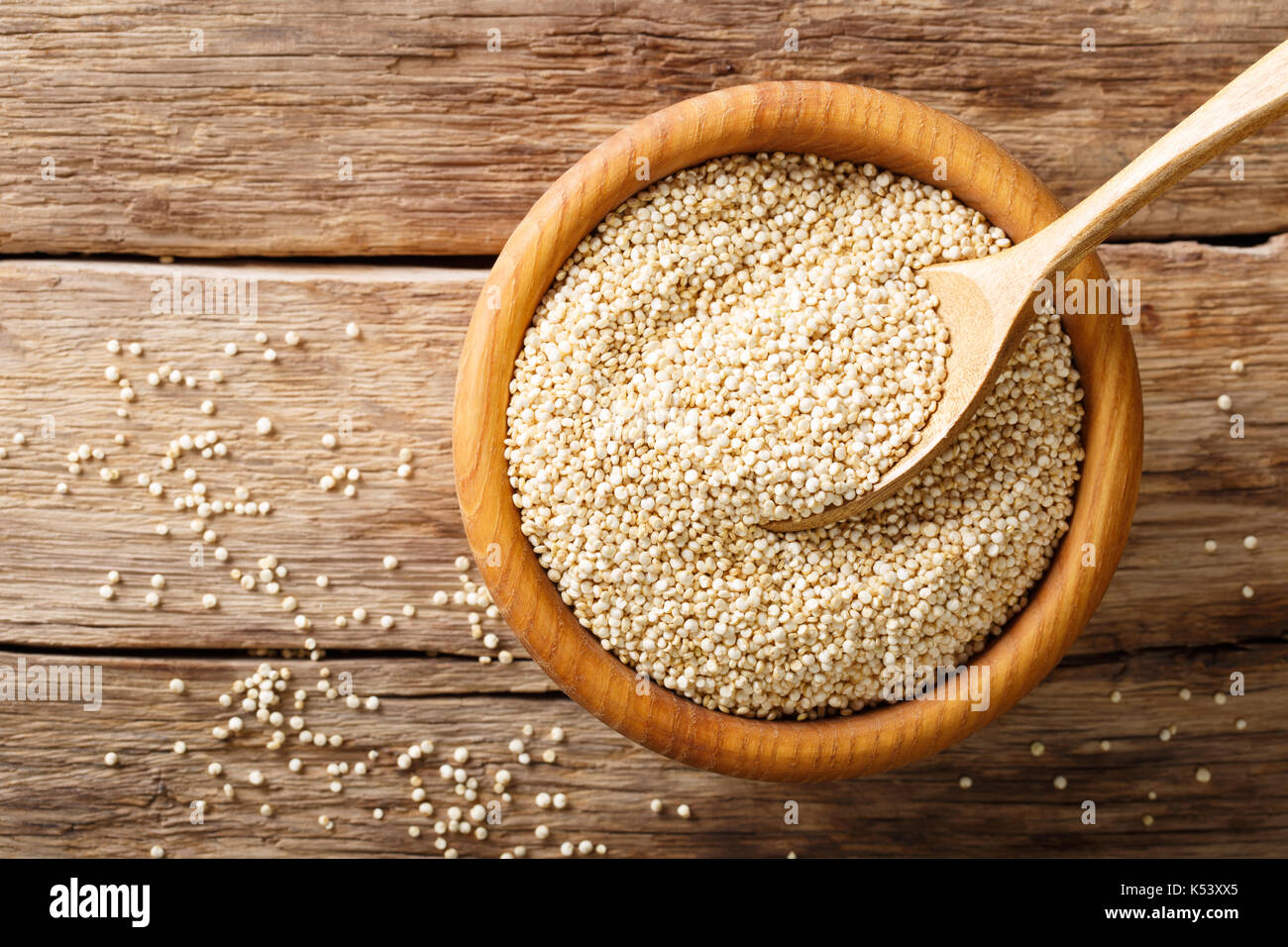 Materie di quinoa vicino fino in una ciotola di legno sul tavolo. vista in pianta da sopra lo sfondo orizzontale Foto Stock