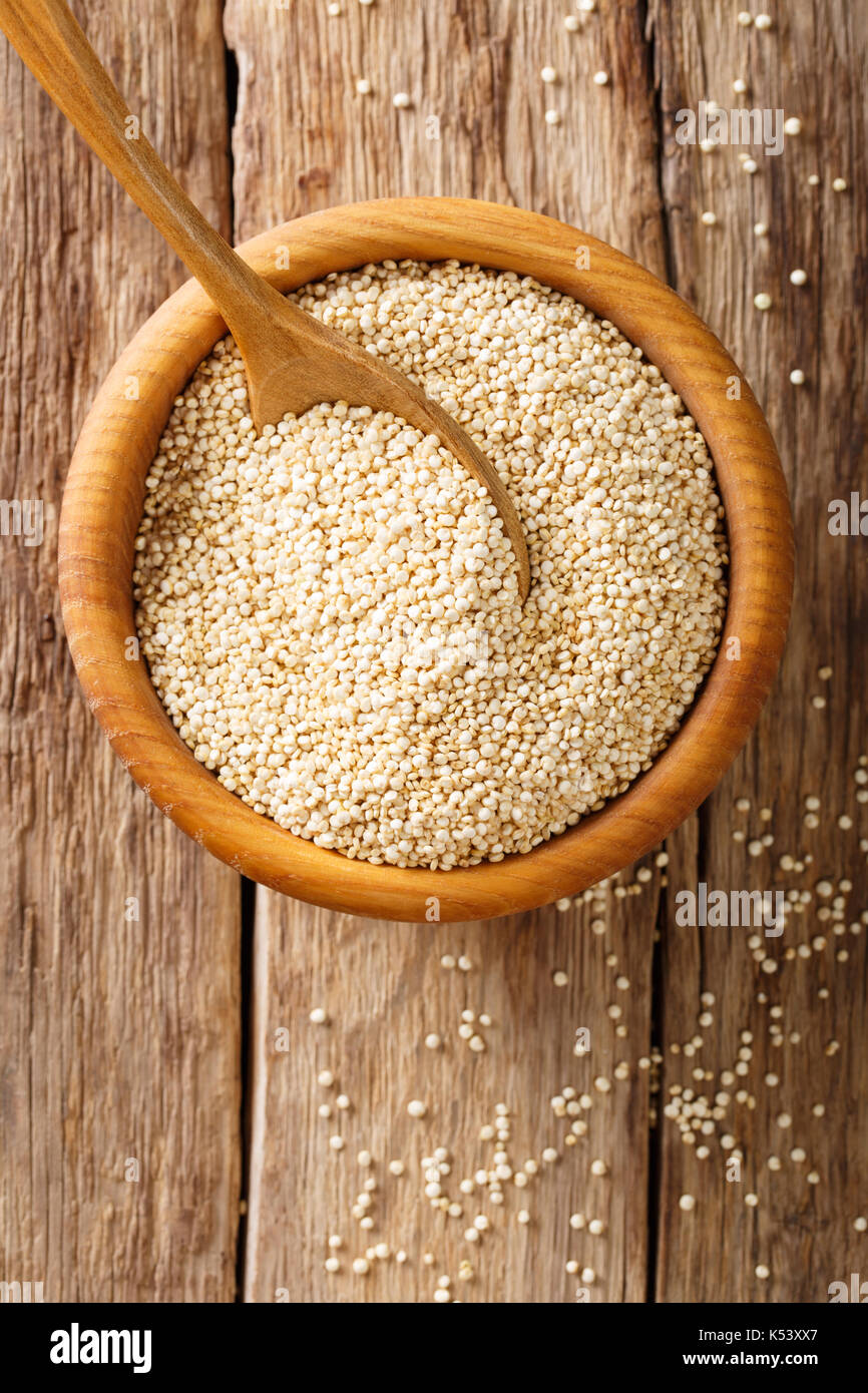 Materie di quinoa vicino fino in una ciotola di legno sul tavolo. vista in pianta da sopra lo sfondo verticale Foto Stock