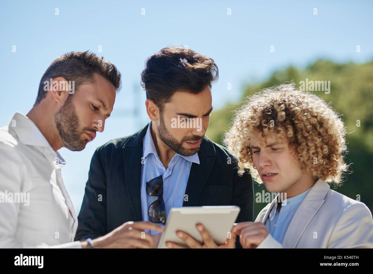 Ritratto di tre uomini di affari utilizzando tablet al di fuori Foto Stock