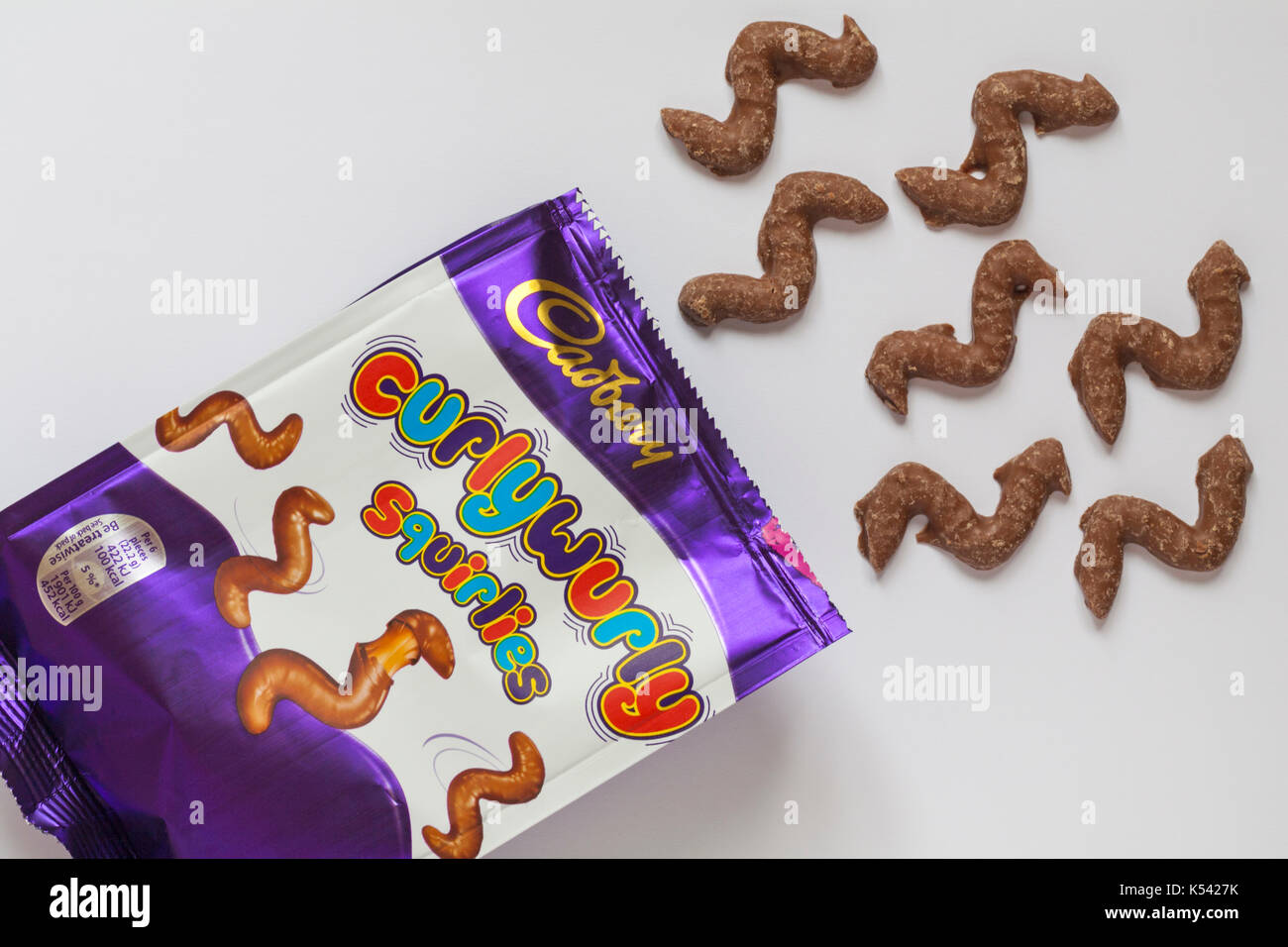 Pacchetto di nuovo Cadbury curlywurly squirlies aperto con contenuto versato impostato su sfondo bianco Foto Stock