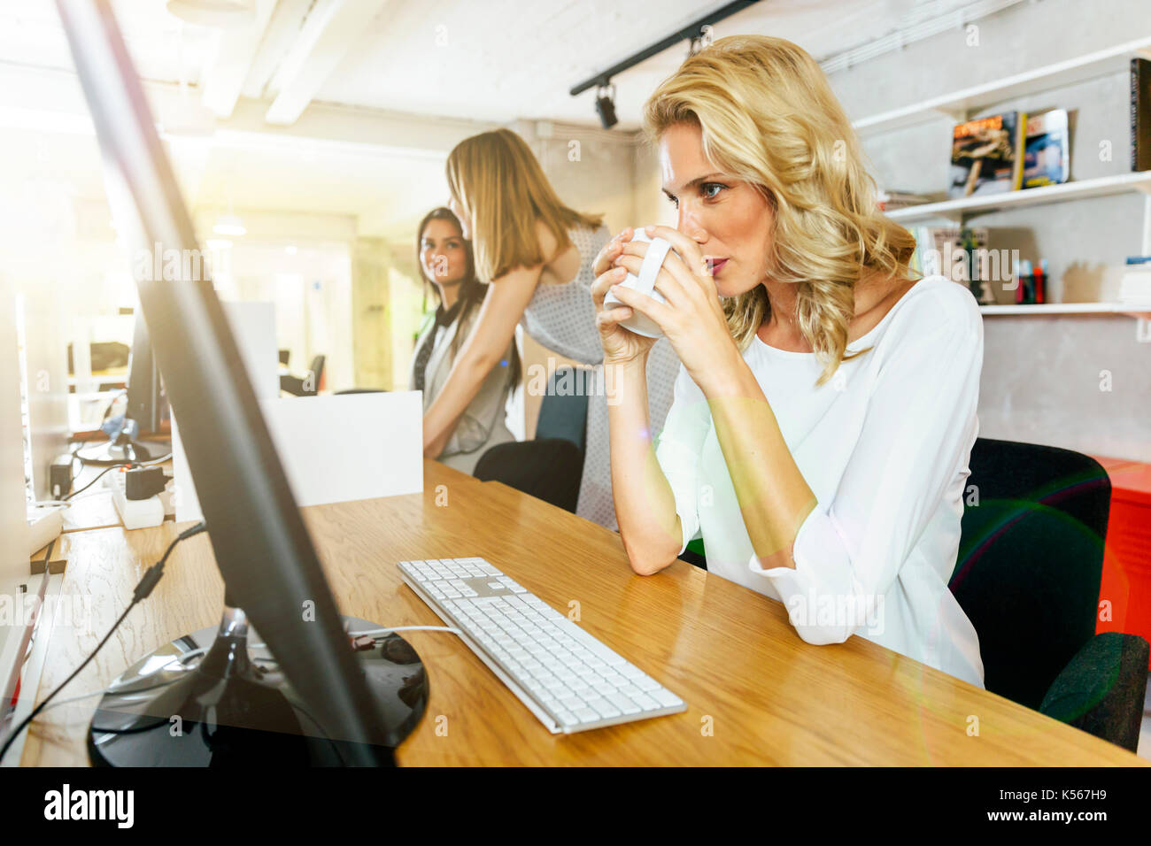 Bella imprenditrice di bere il caffè per rimanere alert Foto Stock