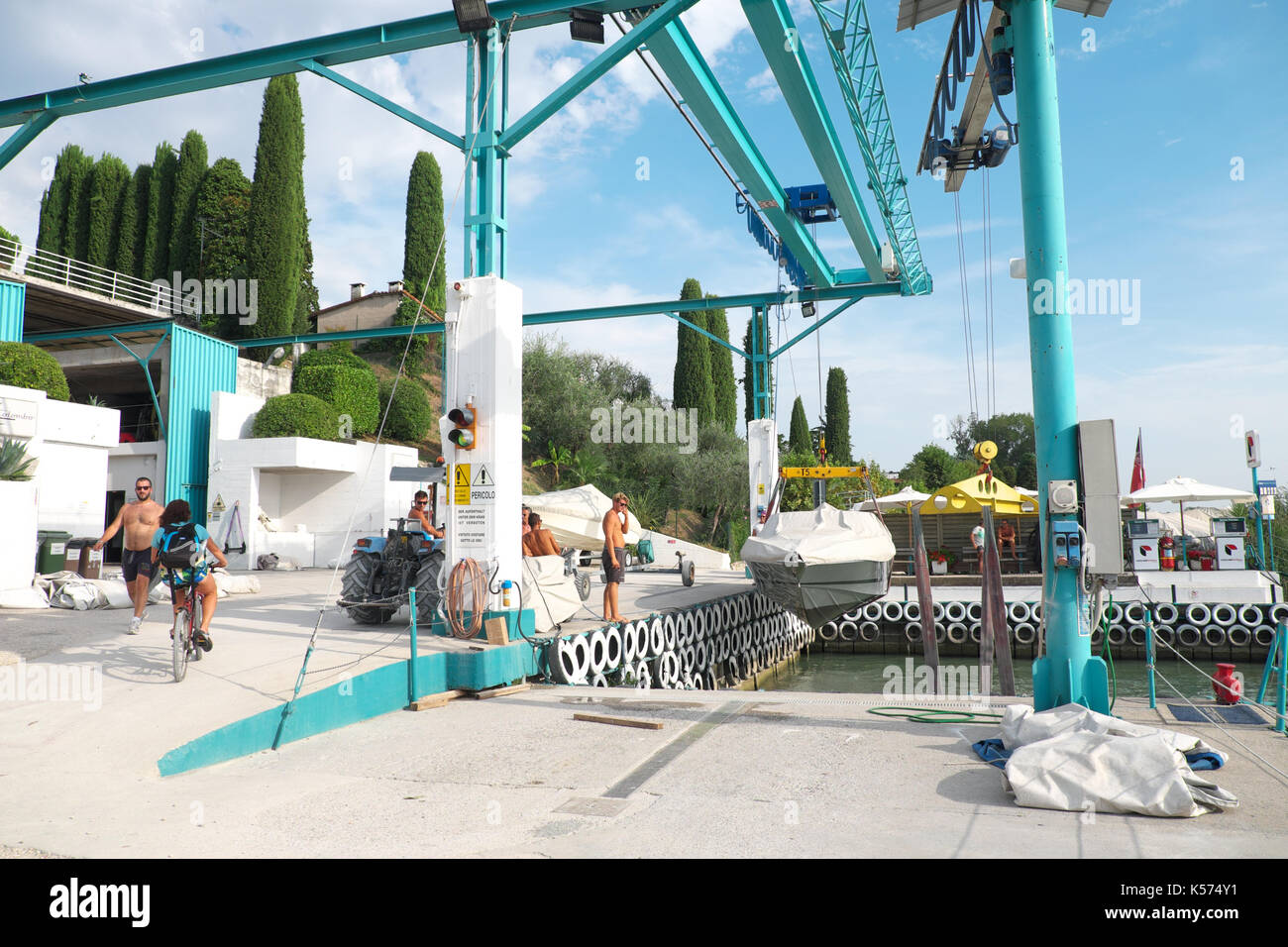 Lazise, sul lago di garda una piccola imbarcazione a motore viene sollevato fuori del lago e in una barca Cantiere di manutenzione Foto Stock