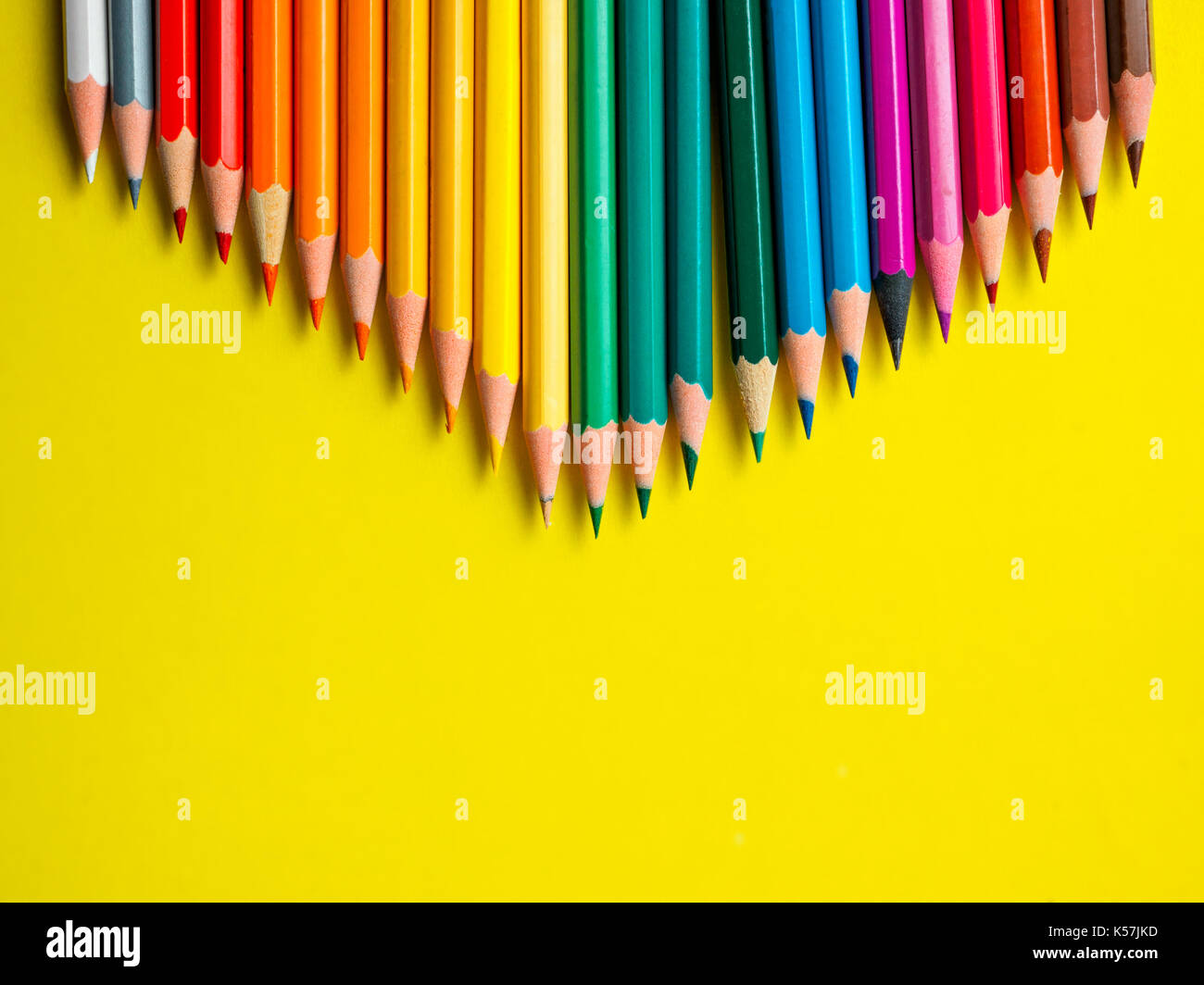 Matite colorate su carta gialla sfondo per disegno cerchio di colore Foto Stock