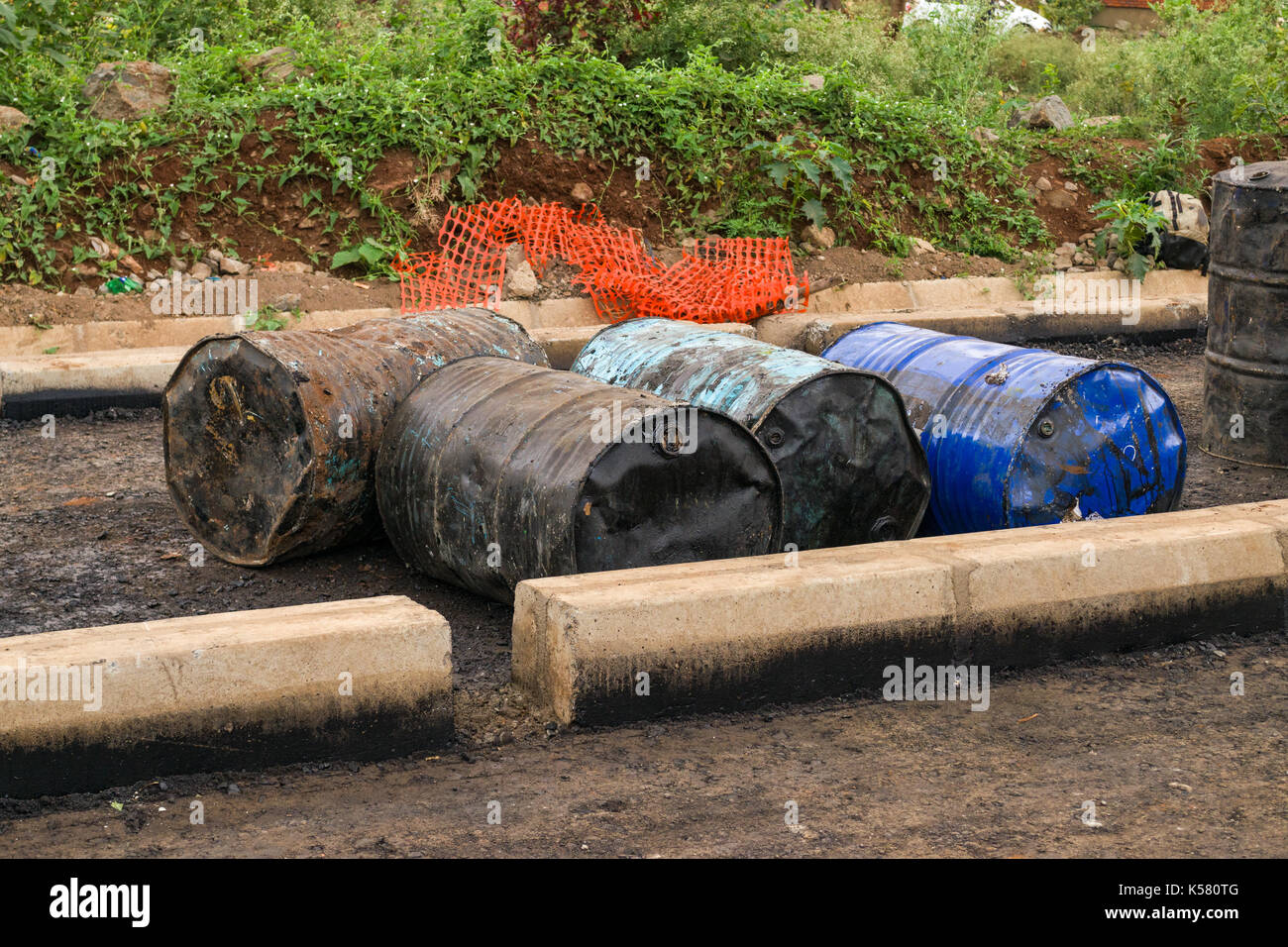 Acciaio vecchi fusti di olio di blocco stradale in costruzione, Nairobi, Kenia Foto Stock