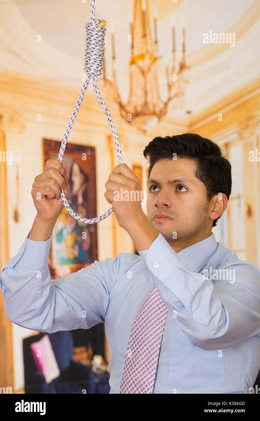 Premuto l'uomo con una corda in mano la preparazione di mettere intorno al  suo collo, in un background in camera Foto stock - Alamy