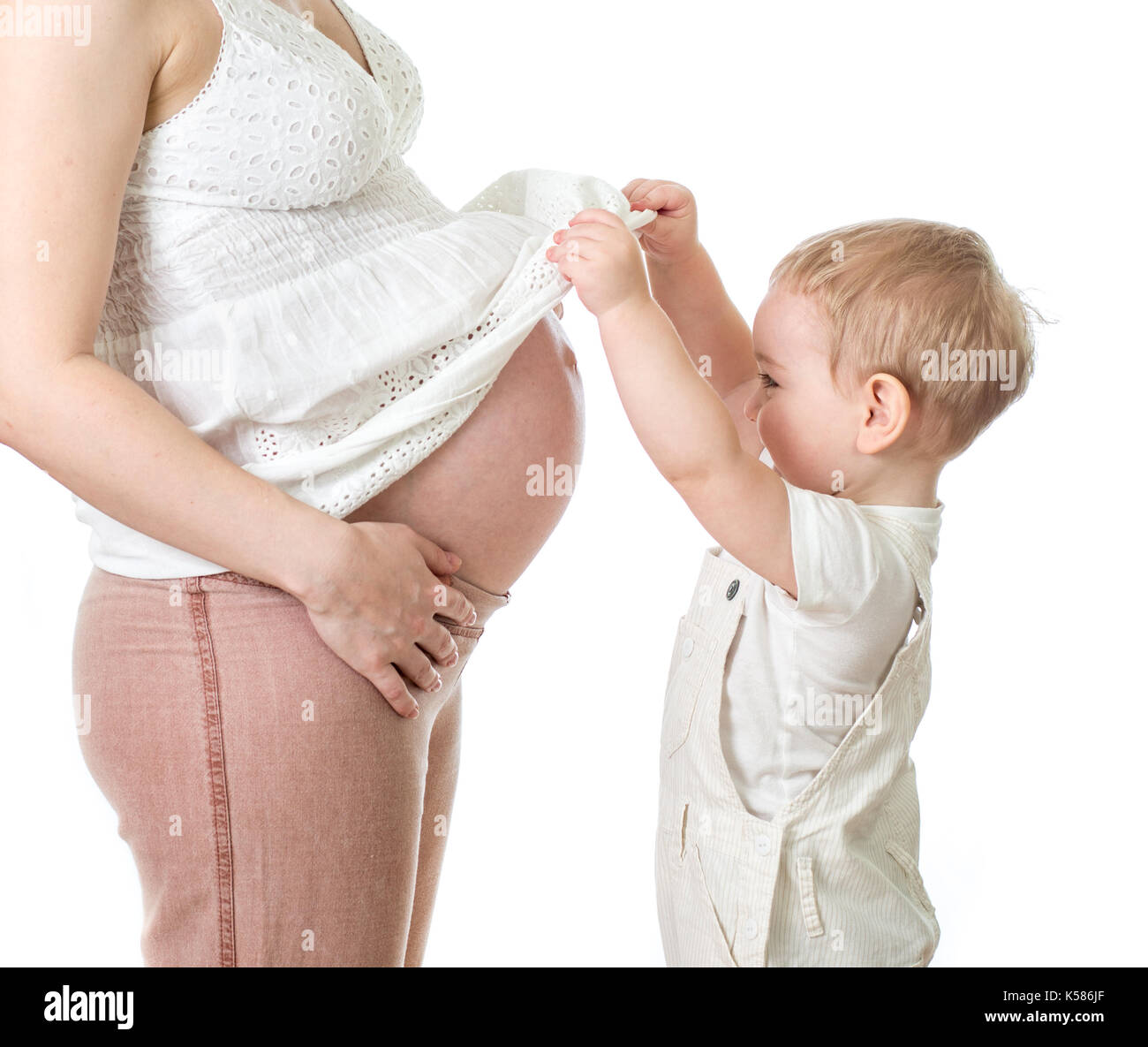 Little Boy guardando sulla gravidanza della madre ventre Foto Stock