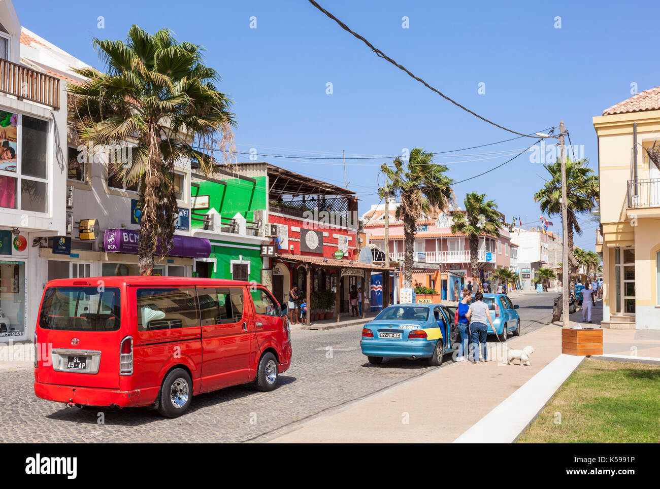 SAL i taxi locali e aluguer o condiviso di guida auto giù per la strada principale, Rua 1 de Junho, Praca centrale, Santa Maria, Isola di Sal Capo Verde Foto Stock