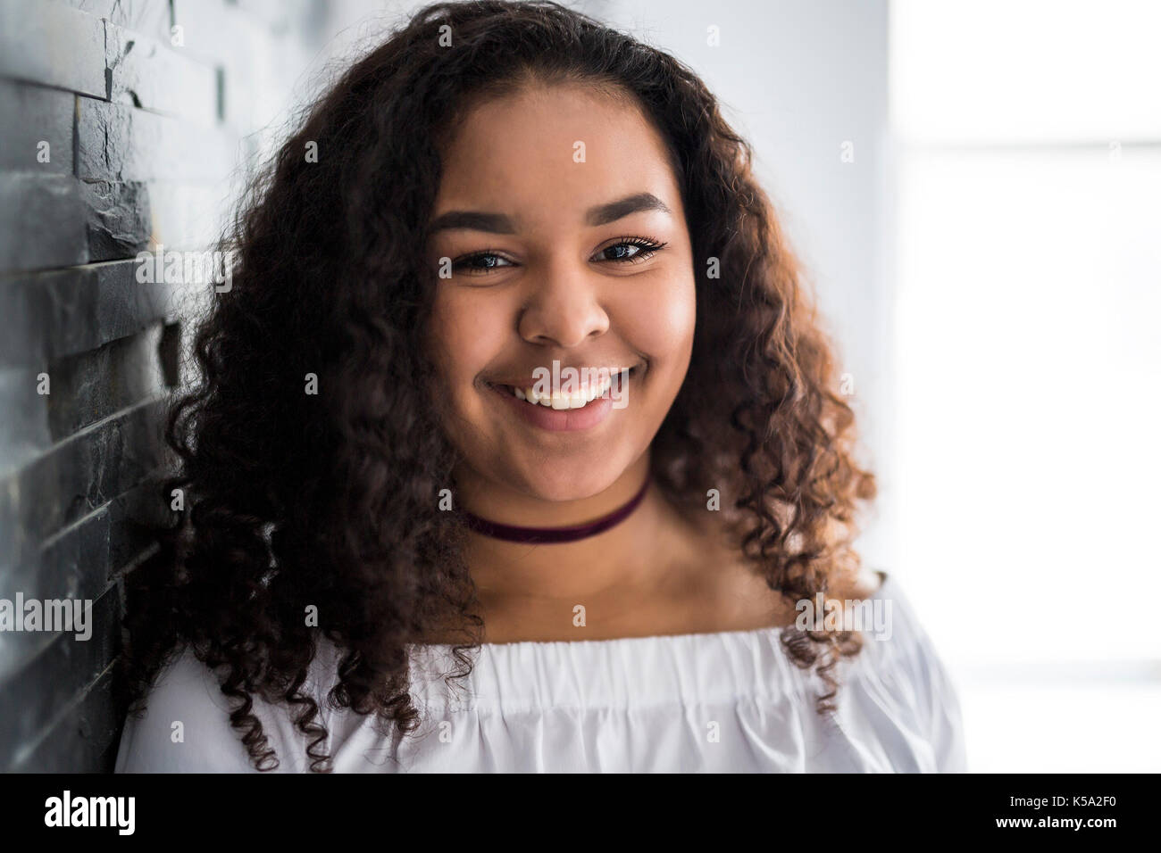 Giovani piuttosto AFRICAN-AMERICAN girl in posa allegro Foto Stock