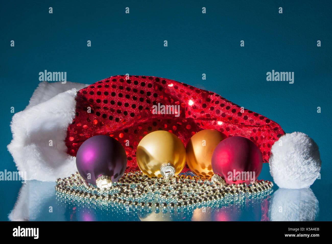 Colorate palle di Natale, santa testa e catenina con riflessioni Foto Stock