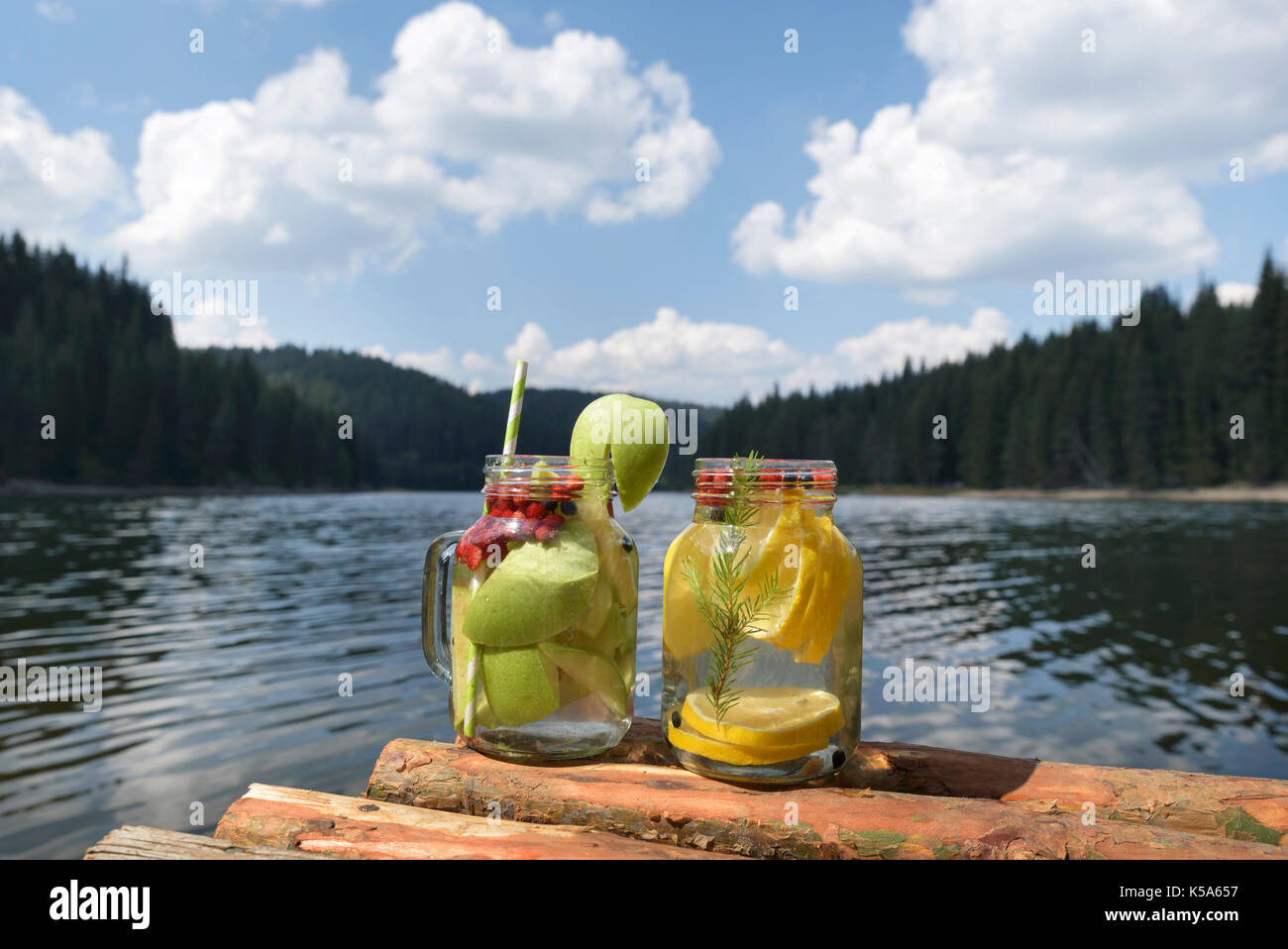 Due vasi di vetro su un molo con acqua infusa Foto Stock