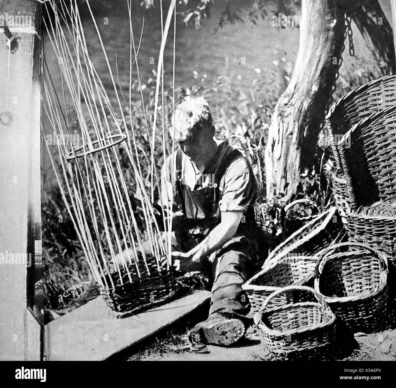 Un paese britannico artigiano (vimini Weaver) rendendo cestelli - 1930 fotografia. Foto Stock