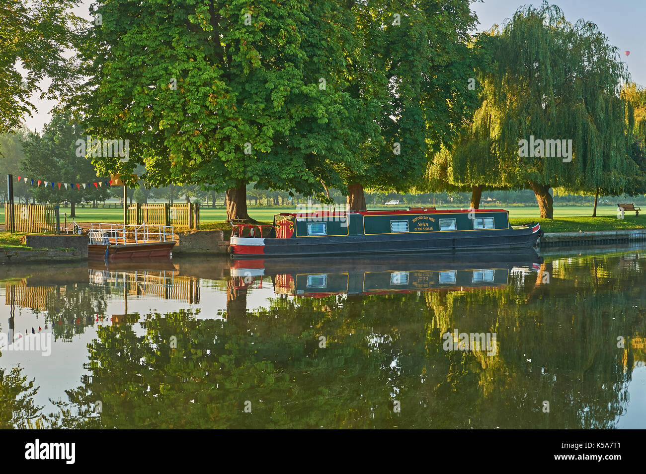 Stratford upon Avon e la mattina presto autunno riflessioni sul fiume Avon con una stretta barca ormeggiata presso la vecchia catena traversata in traghetto. Foto Stock