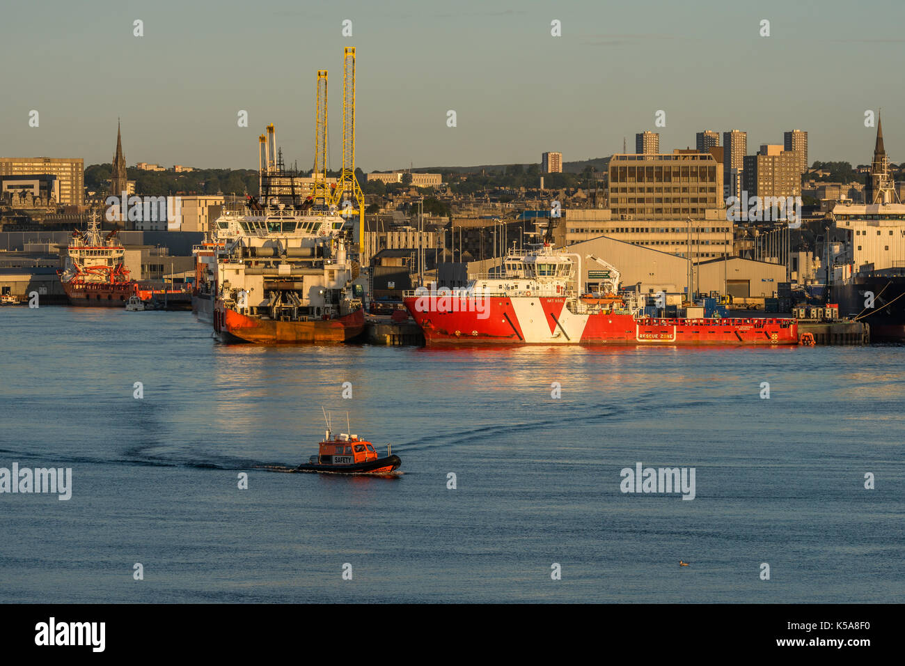 Aberdeen, Scozia, Regno Unito, 30 agosto 2017. aberdeen bacino portuale, navi, piloni, il centro città e la piccola imbarcazione di salvataggio. Foto Stock