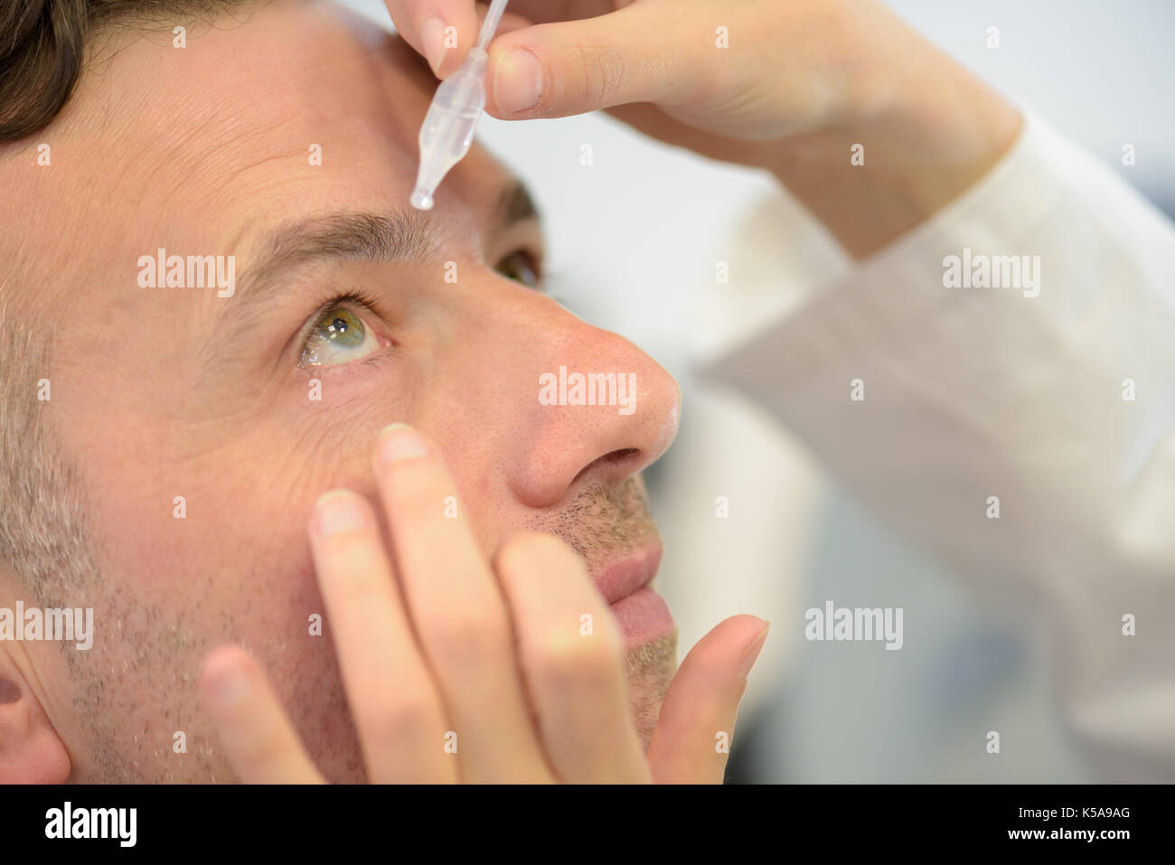 Uomo con lozione oculare Foto Stock