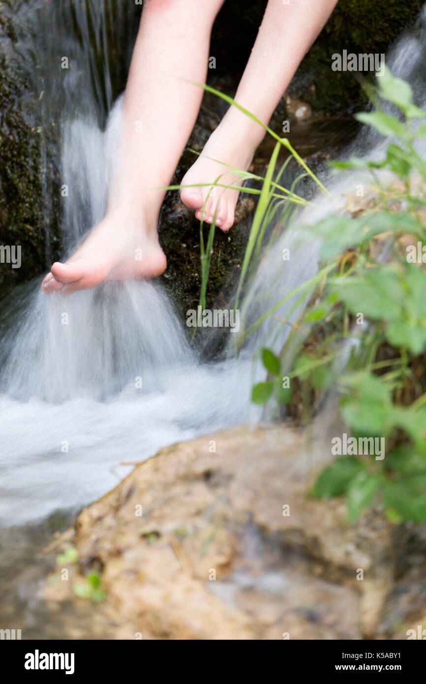 Donna bagnando i suoi piedi in un flusso. svolgerà in bogarra, provincia di Albacete, Spagna. Foto Stock