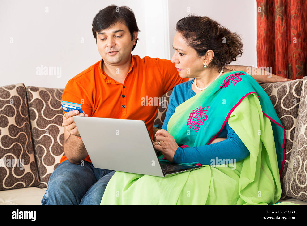 Figlio di adulti e senior madre laptop carta di credito shopping on line Foto Stock