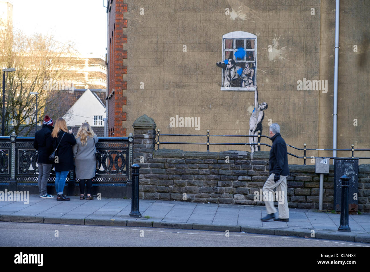 Un banksy arte il lavoro sul lato di un edificio visto dal basso di park st, bristol. Il graffito è di per sé era soggetto ad atti vandalici con vernice blu Foto Stock