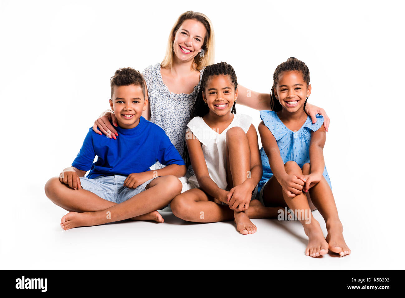 Afro twin di bambino e di bambino in posa su uno sfondo bianco con studio madre bianco Foto Stock