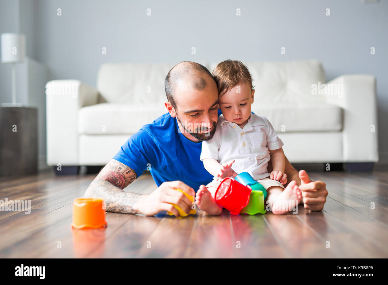 Padre Felice e piccolo figlio di giocare con blocchi giocattolo a casa Foto Stock