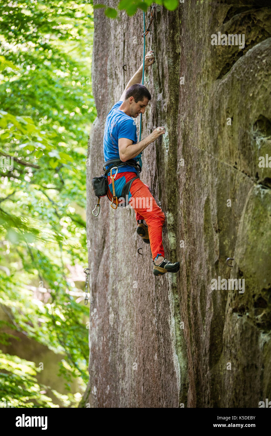 Giovane maschio rocciatore sul percorso impegnativo su roccia verticale Foto Stock