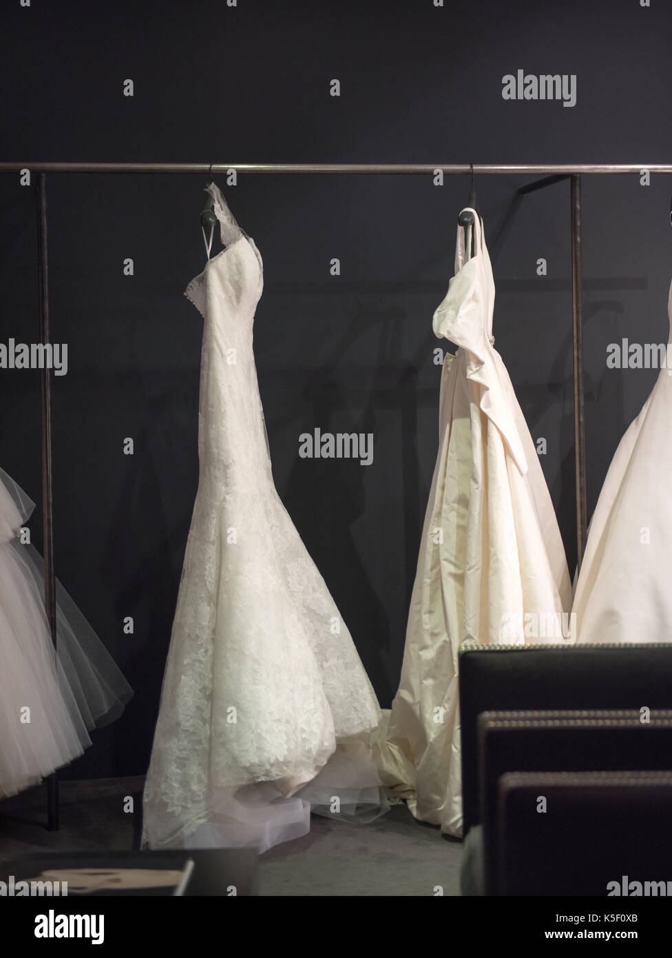 Selezione di bianco abiti da sposa o abiti a sfera sul display appeso su rotaie con il fuoco selettivo per una illuminata da evidenziare Foto Stock