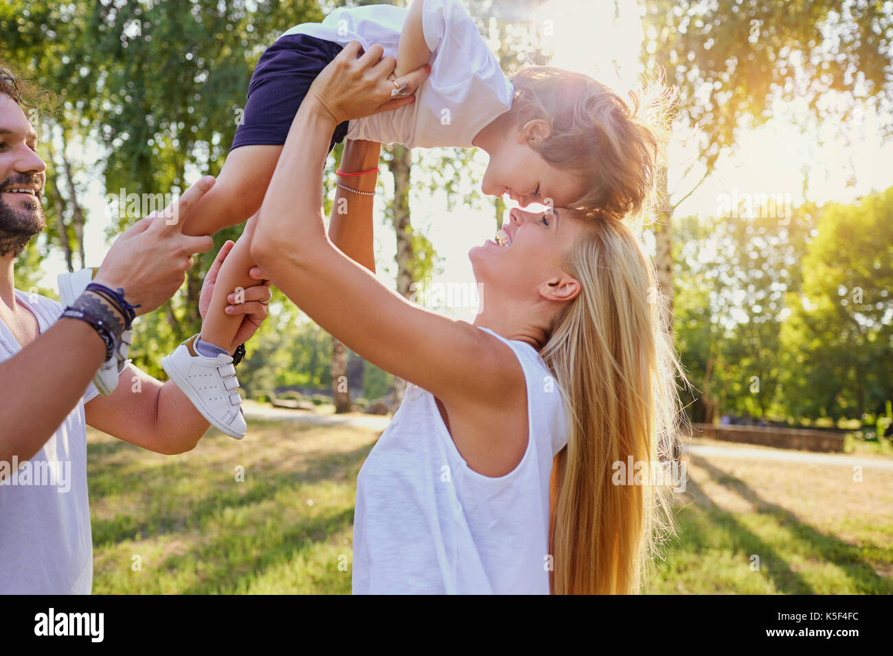 La famiglia felice a giocare con un bambino nel parco. Foto Stock