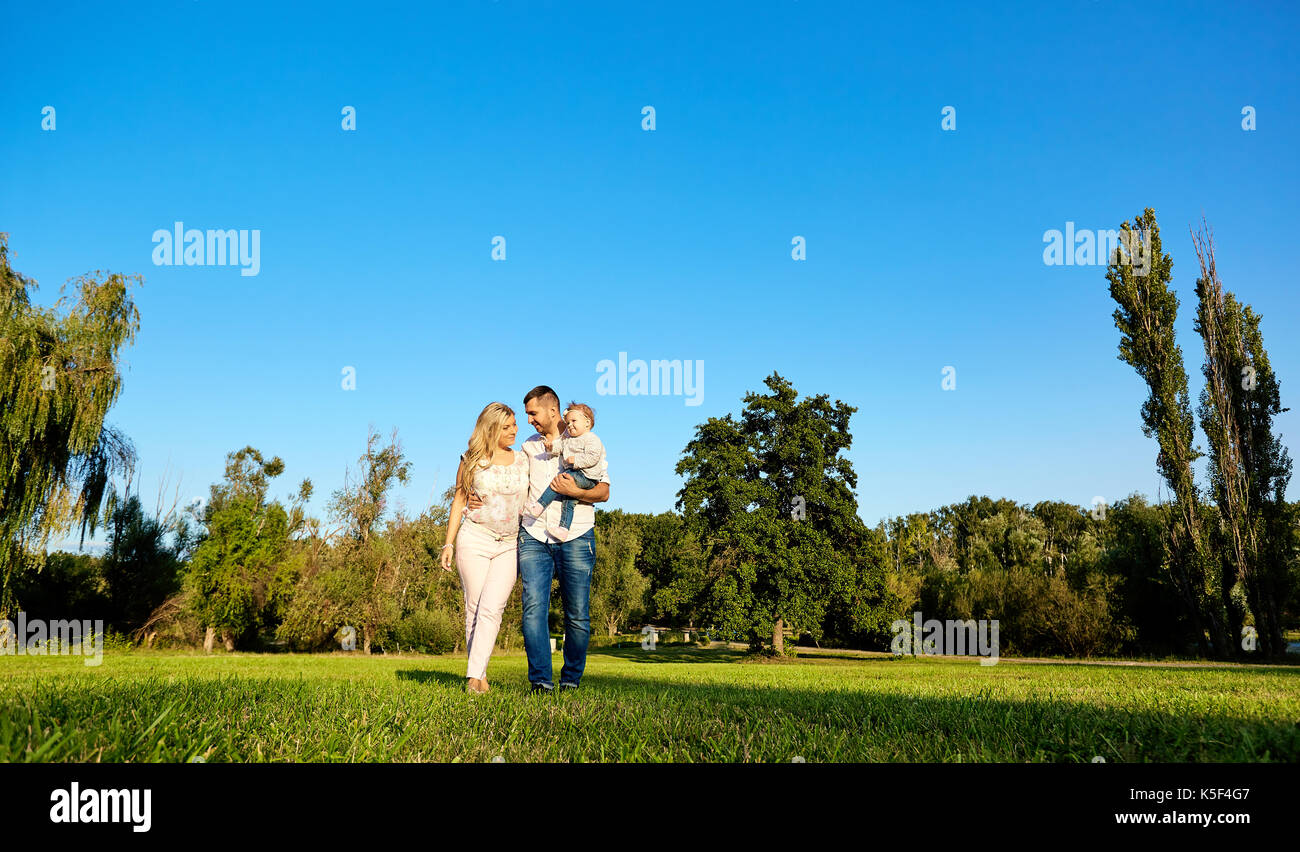 Felice famiglia giovane nel parco in una giornata di sole. Foto Stock