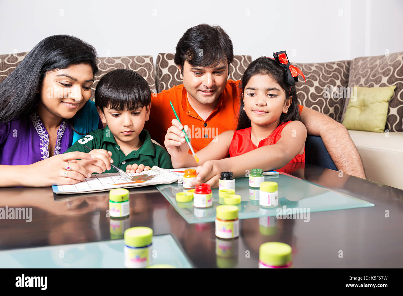 Indian genitori e bambini istruzione disegno pittura contribuendo istruzione Foto Stock