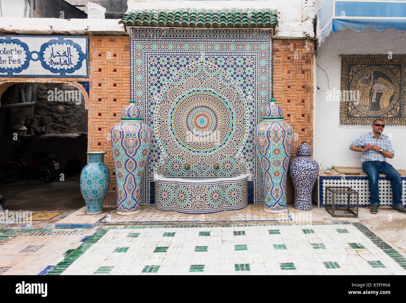 Fez, in Marocco - Maggio 07, 2017: marocchina operaio di fabbrica del mosaico nella factory di Fez è seduta su una panchina di fumare una sigaretta nel cortile accanto a un Foto Stock