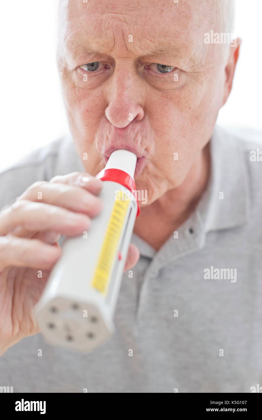 Senior uomo con misuratore del picco di flusso espiratorio. Foto Stock