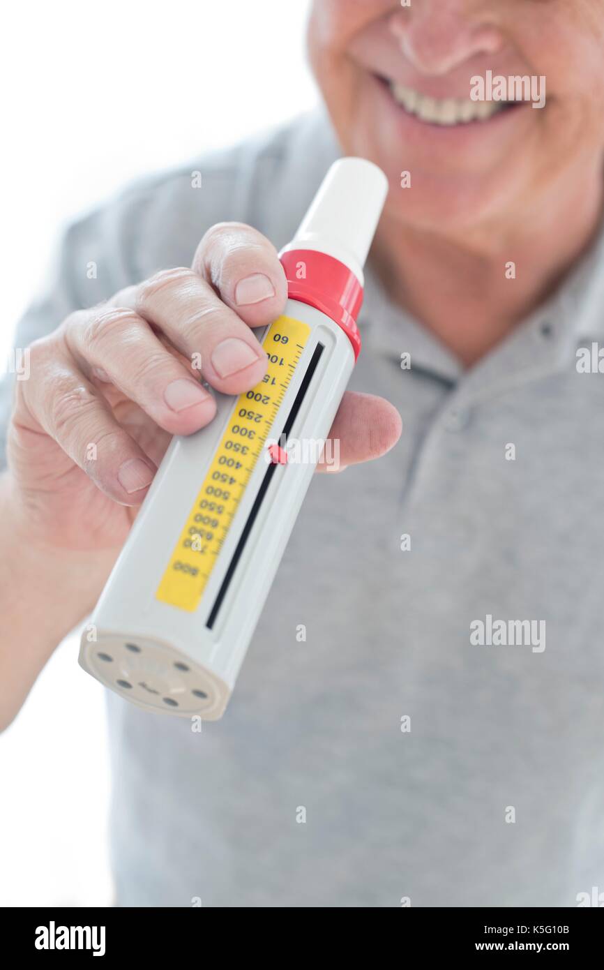 Senior uomo con misuratore del picco di flusso espiratorio. Foto Stock