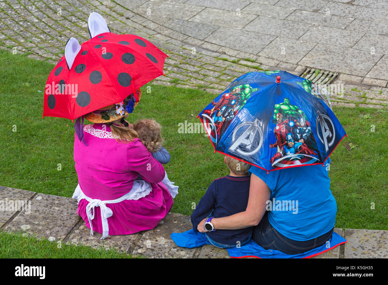 Swanage, Dorset, Regno Unito. 9 Sep, 2017. Regno Unito meteo: heavy rain e tuoni a Swanage. La gente seduta sulla parete sotto gli ombrelloni cercando di mantenere asciutto. Credito: Carolyn Jenkins/Alamy Live News Foto Stock