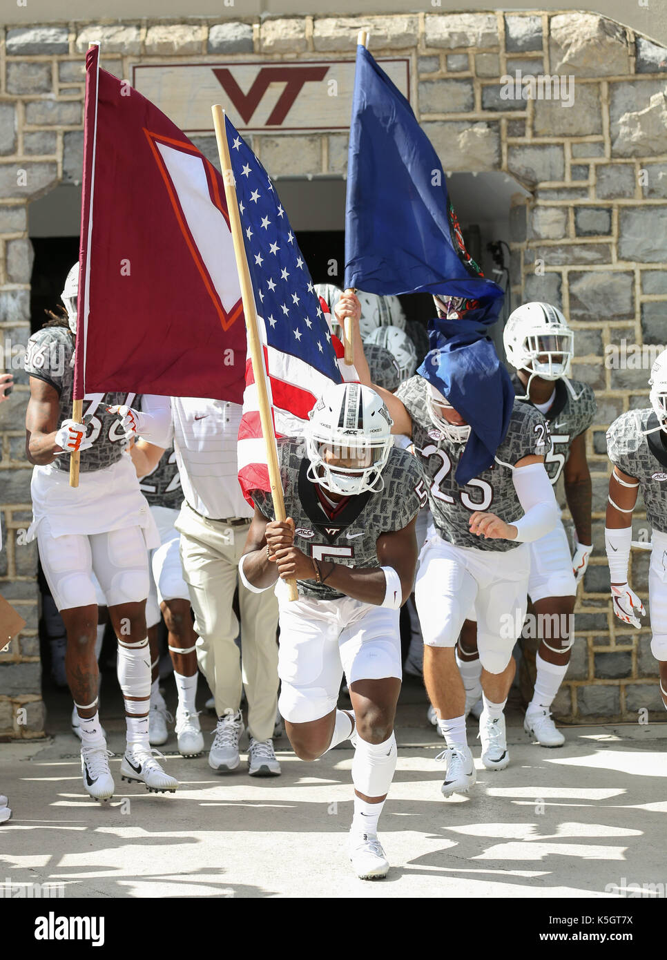 Blacksburg, VA, Stati Uniti d'America. 9 Sep, 2017. Cam Philips #5 porta la bandiera americana e conduce al Virginia Tech Hokies sul campo prima di NCAA Football gioco tra il Virginia Tech Hokies e il Delaware Blue galline a Lane Stadium/Worsham Campo in Blacksburg, VA. Kyle Okita/CSM/Alamy Live News Foto Stock