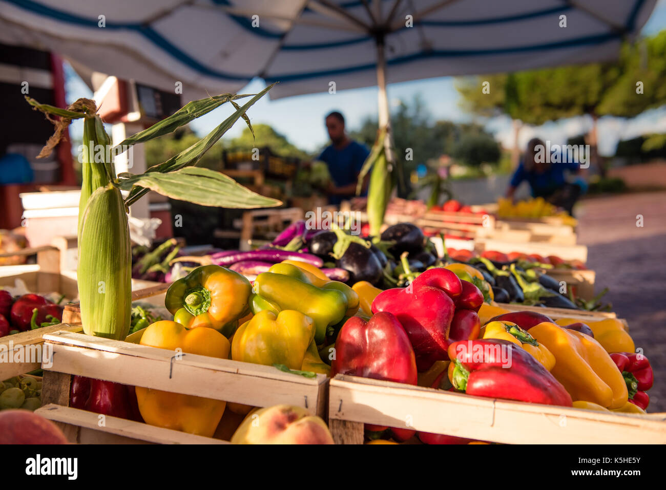 Pressione di stallo di mercato piena di colorati verdure, vicino la messa a fuoco selettiva su giallo e pepe rosso heap Foto Stock