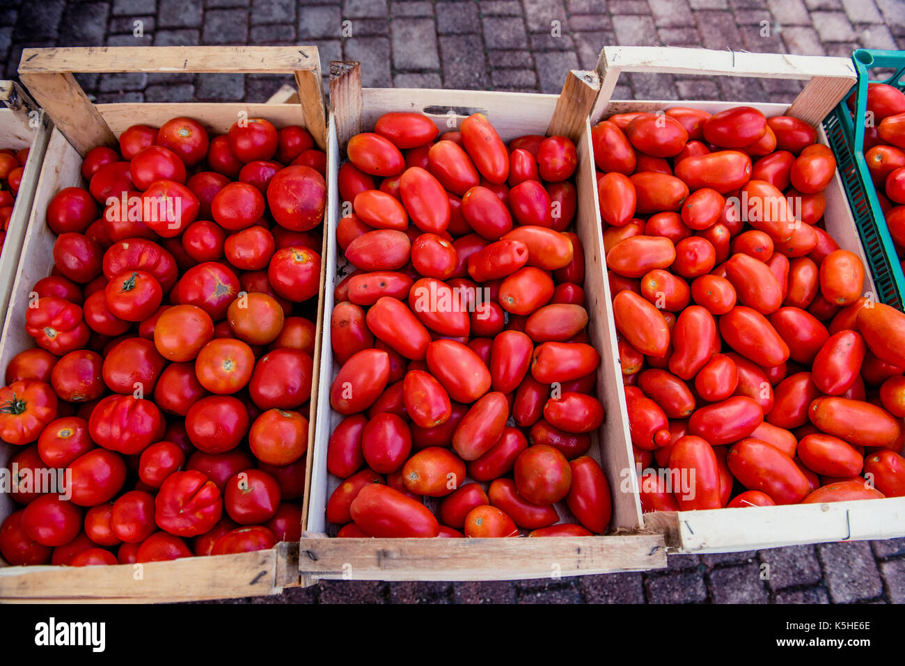 Pressione di stallo di mercato casse di legno pieno di diverse varietà di pomodori cimelio italiana e san marzano, vicino fino ad alto angolo di visione Foto Stock