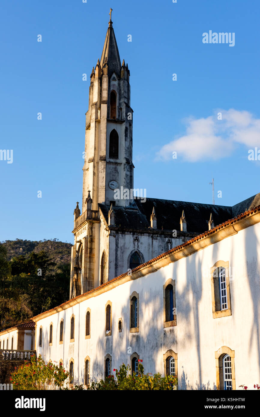 Vista laterale del Santuario Caraca neo-gotica chiesa al crepuscolo, la Chiesa Cattolica e il lodge principale, Minas Gerais, Brasile. Foto Stock