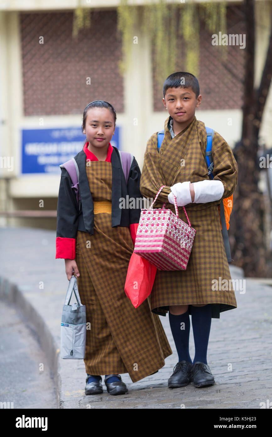 Gli scolari sul loro modo alla scuola del paese indossando il tradizionale costume bhutanesi come uniforme in thimphu Bhutan occidentale. Foto Stock