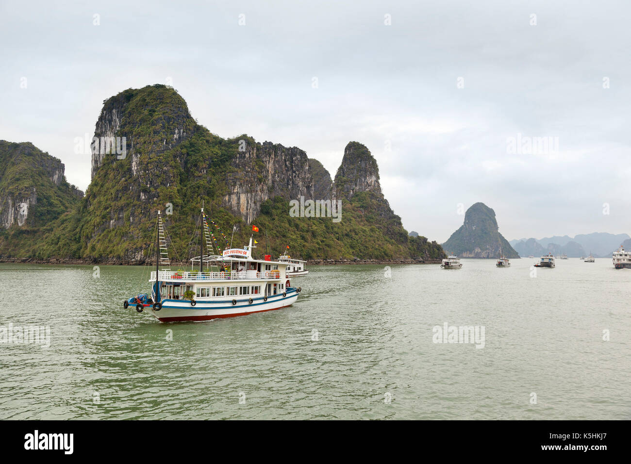 Tour barche navigando tra le isolette di calcare, Halong Bay, Vietnam. Foto Stock