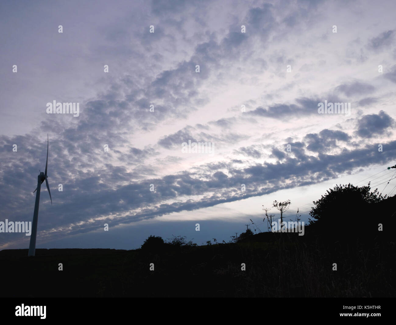 Una turbina eolica stagliano contro il cielo di sera vicino a St Austell, Cornwall. Foto Stock
