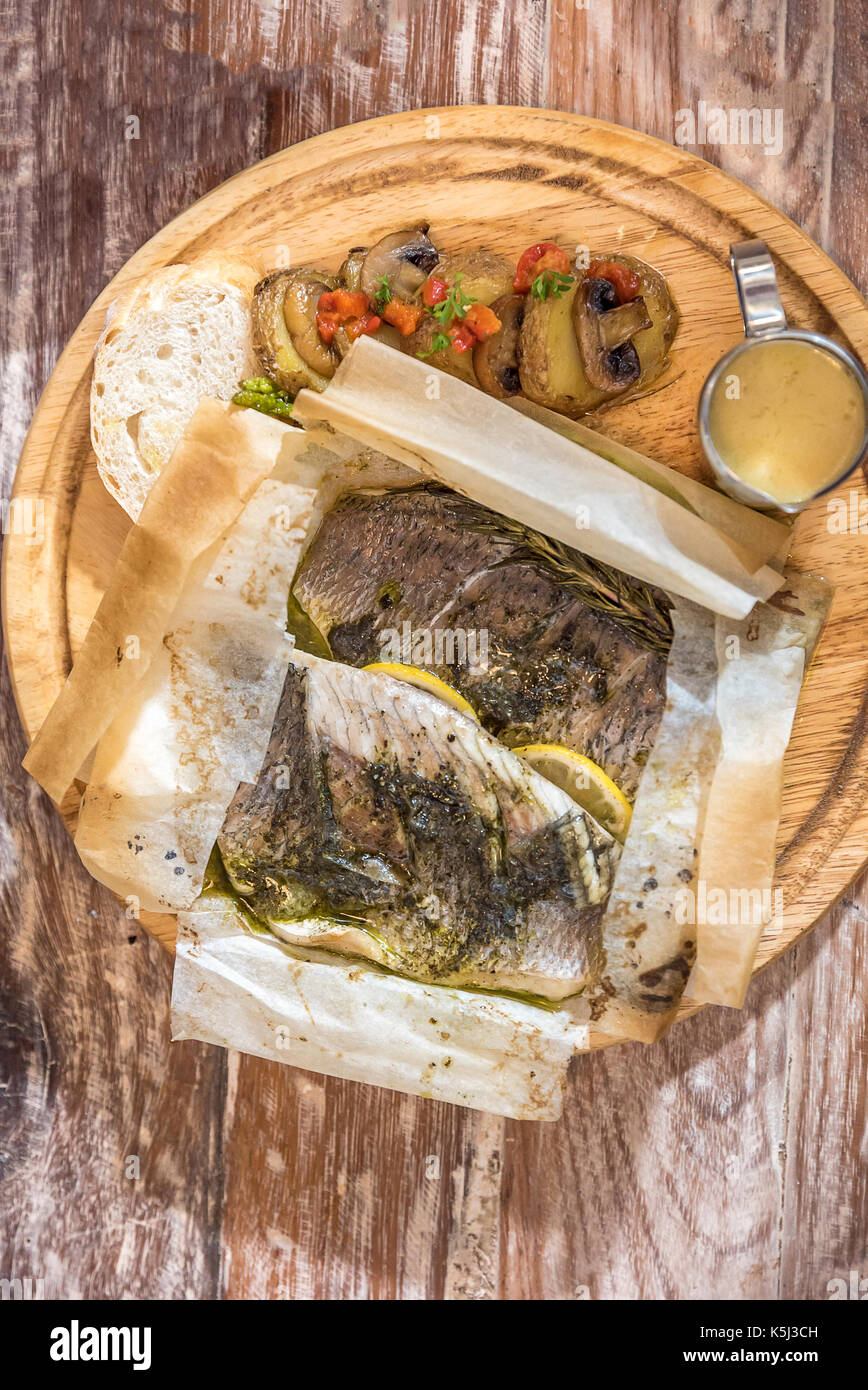 Cotto al forno spigola servito con grigliata di verdure e funghi Foto Stock